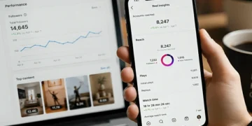 Instagram creator checking Reels analytics and engagement metrics on a smartphone with Instagram performance dashboard on laptop screen