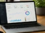 Social media analytics dashboard displayed on a laptop showing Instagram, Facebook, Twitter, and YouTube performance metrics on a modern workspace desk